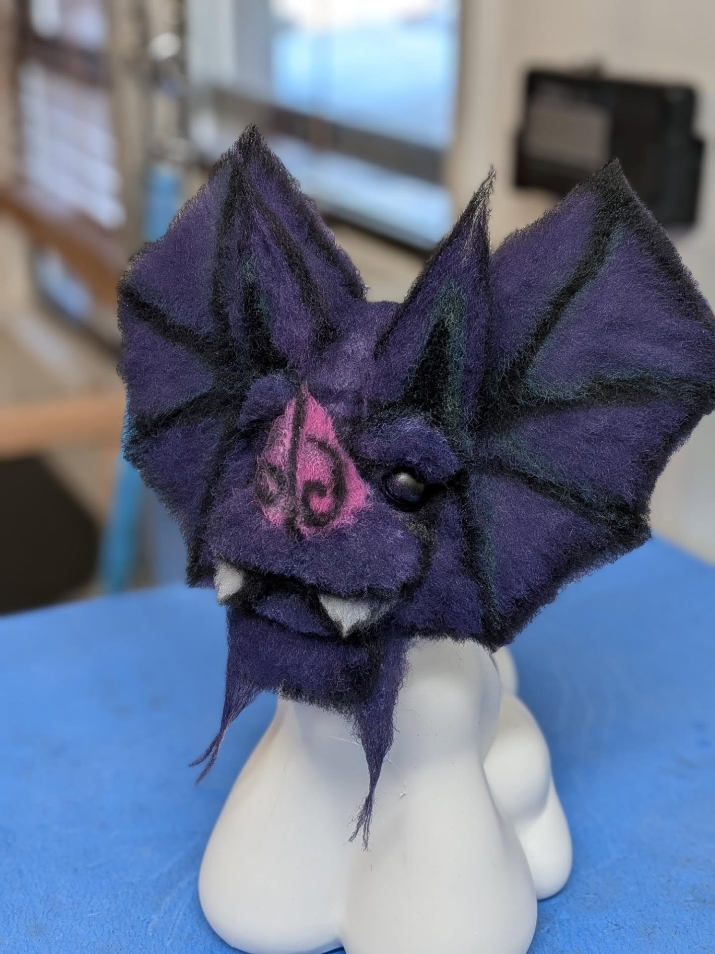 Angled view of the purple bat model dog groom, showing structural carving and multidimensional shaping.