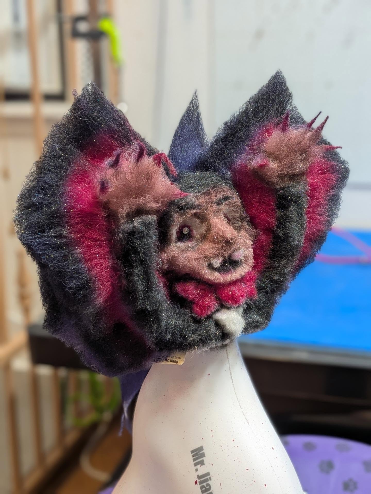 Side view of the same vampire model dog creative groom, showing sculpted wings and layered color placement.